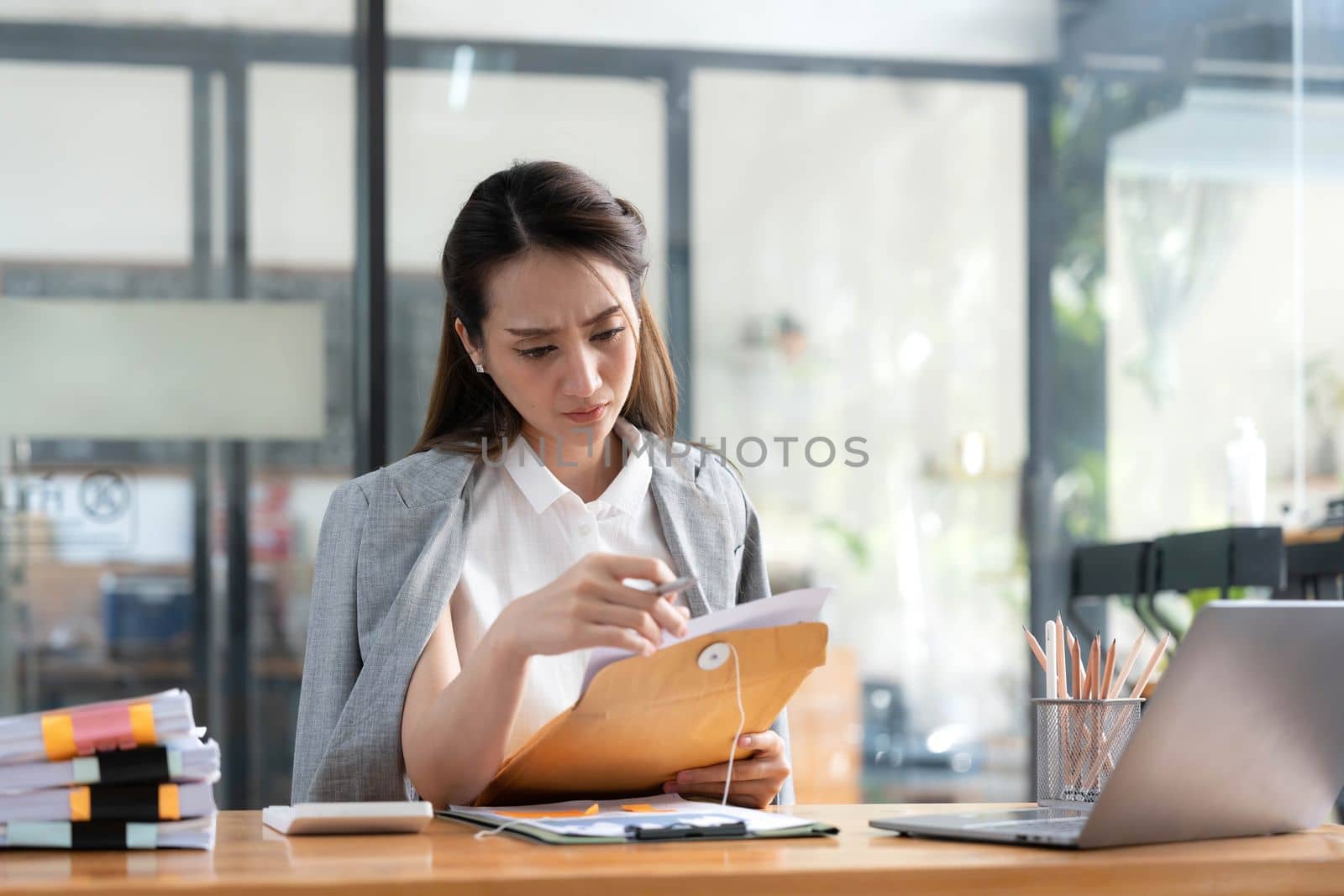 Young Business Asian women are stressed while working on laptop, Tired asian businesswoman with headache at office, feeling sick at work copy space in workplace an home office. by wichayada