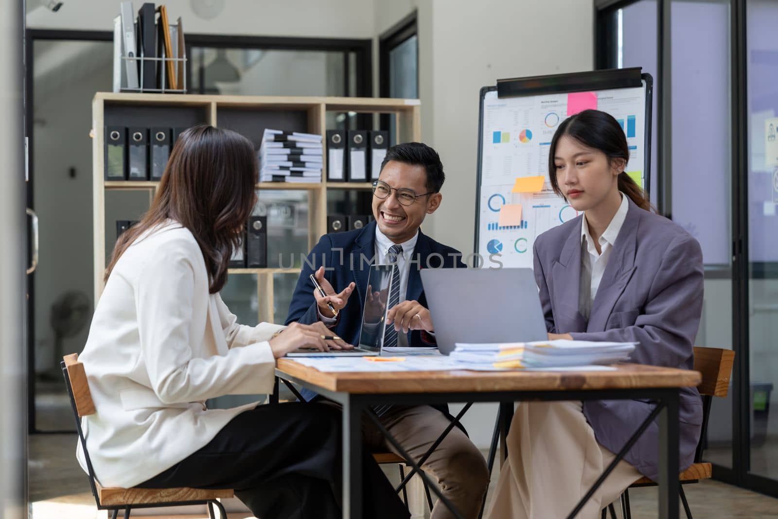 Asian business adviser meeting to analyze and discuss the situation on the financial report in the meeting room.Investment Consultant, Financial advisor and accounting concept