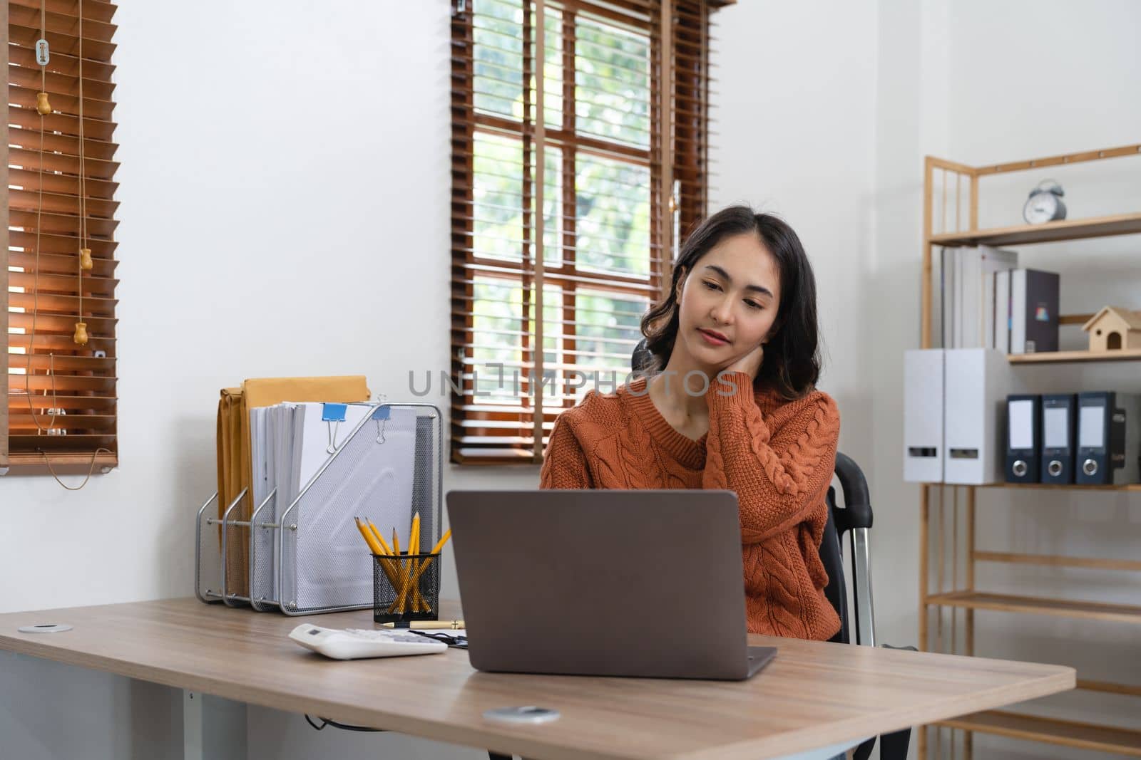 business Asian woman having neck pain while working on computer laptop. office syndrome concept