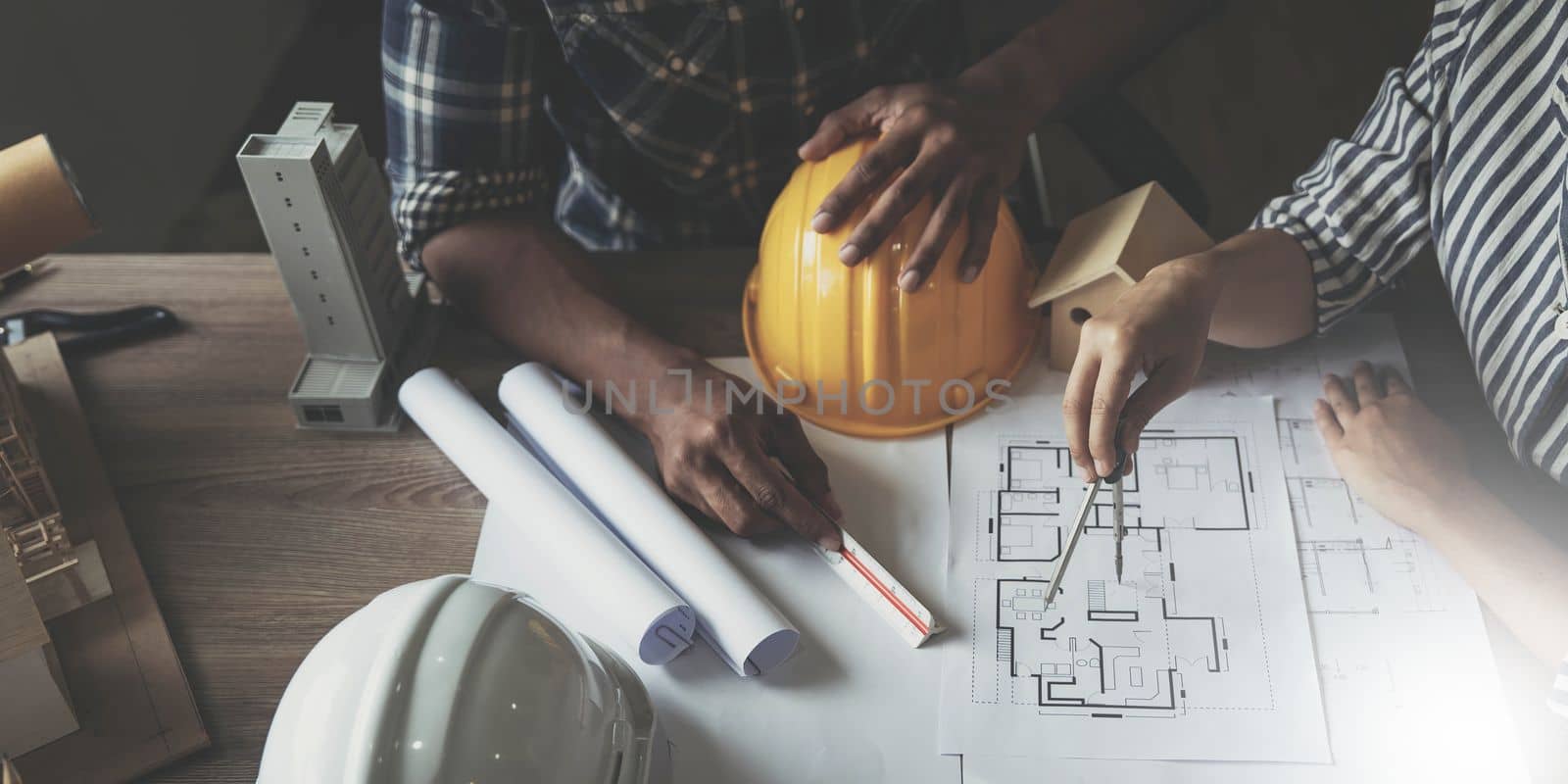 Builder two asian young engineer man and architect woman are discussing construction from a plan to follow the project to build an industrial plant at site. Worker concept. by wichayada