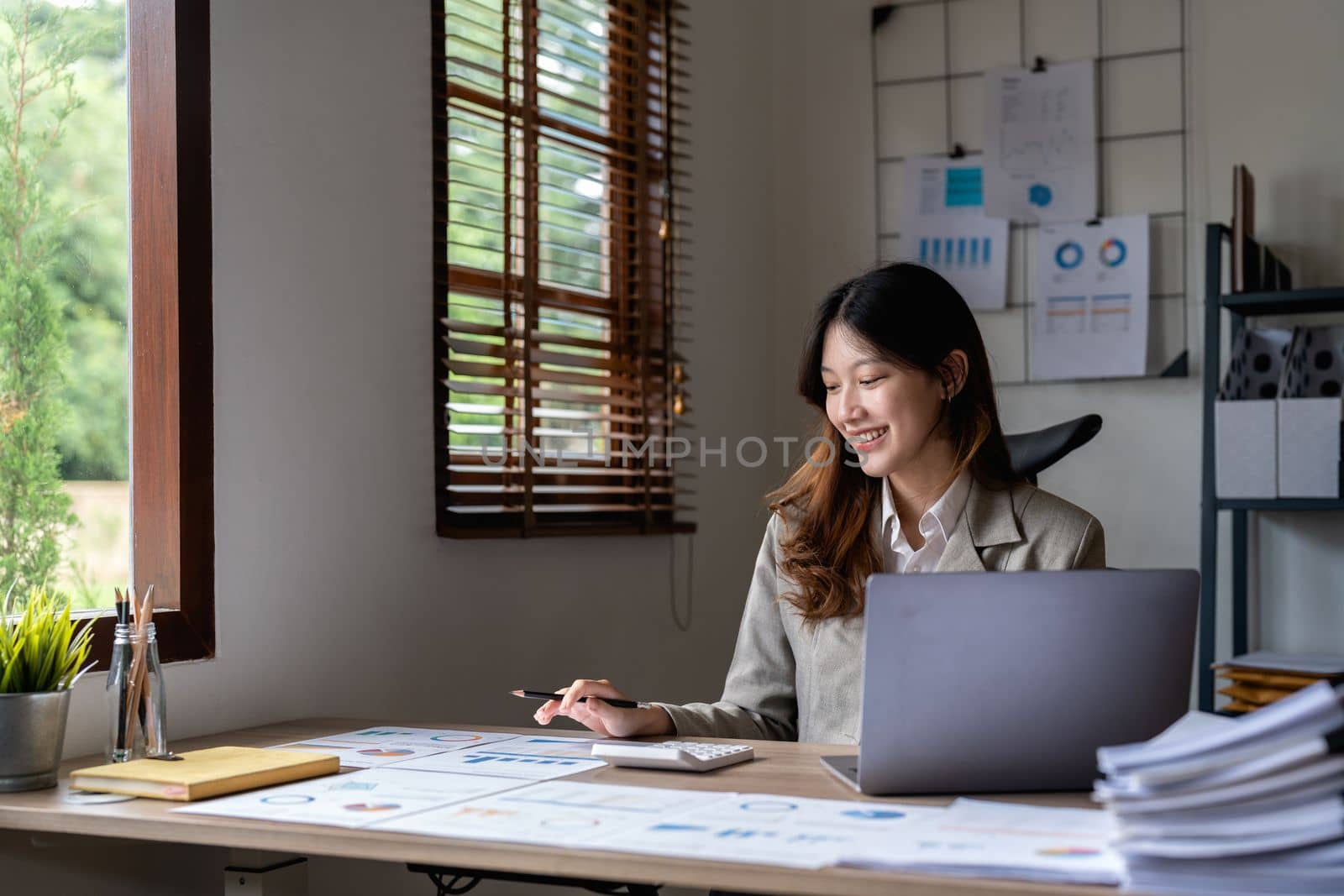 Portrait asian woman accountant working with computer and calculator for business and financial expense.