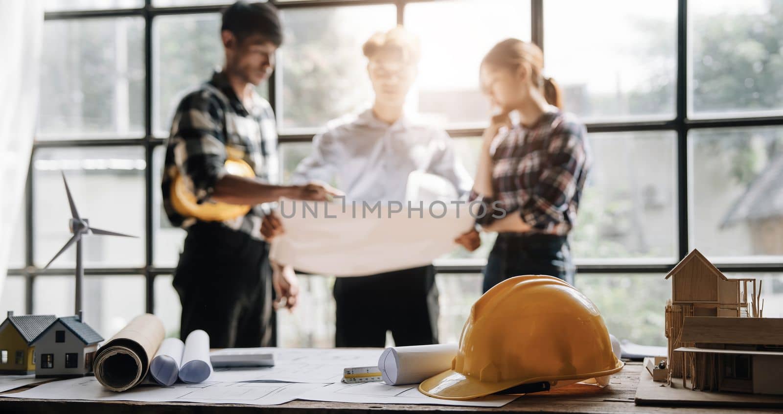 Civil engineer teams meeting working together wear worker helmets hardhat on construction site in modern city. Foreman industry project manager engineer teamwork. Asian industry professional team by wichayada