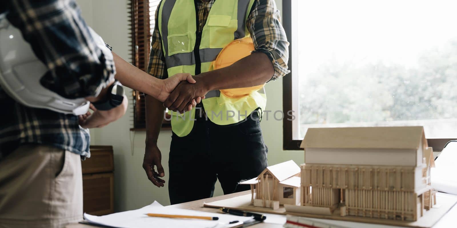 Hand in hand between project contractors and customers due to negotiation of expenses and investments, construction and repair of residential buildings. by wichayada