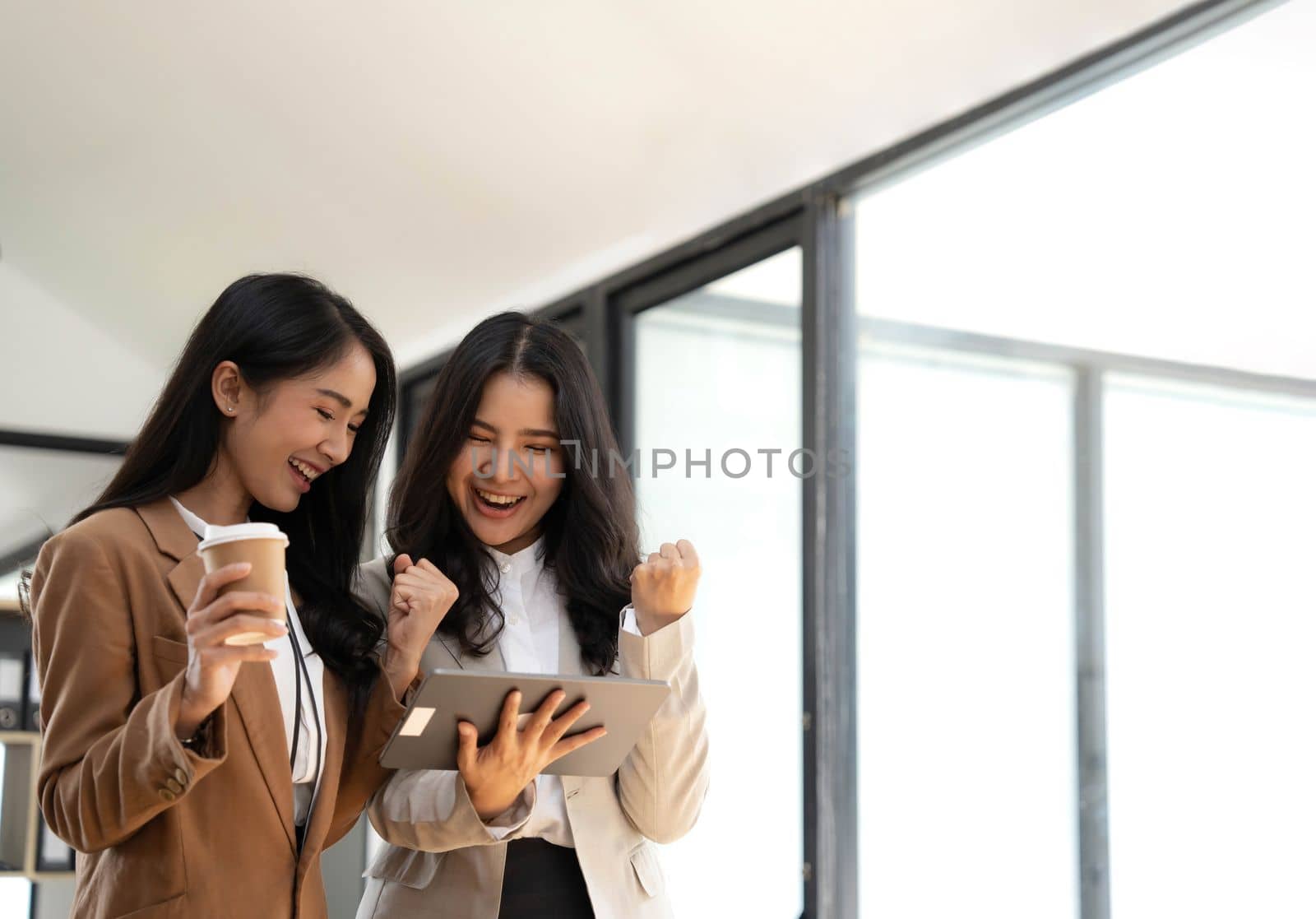 Attractive young asian woman using laptop computer while standing in a office..