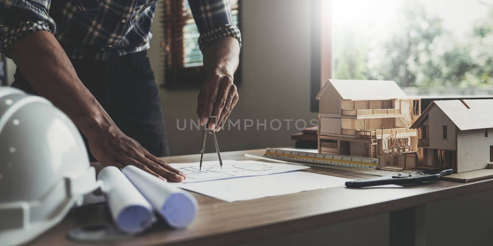 Concept architects, engineer holding pen pointing equipment architects On the desk with a blueprint in the office, Vintage, Sunset light.Selective Focus.