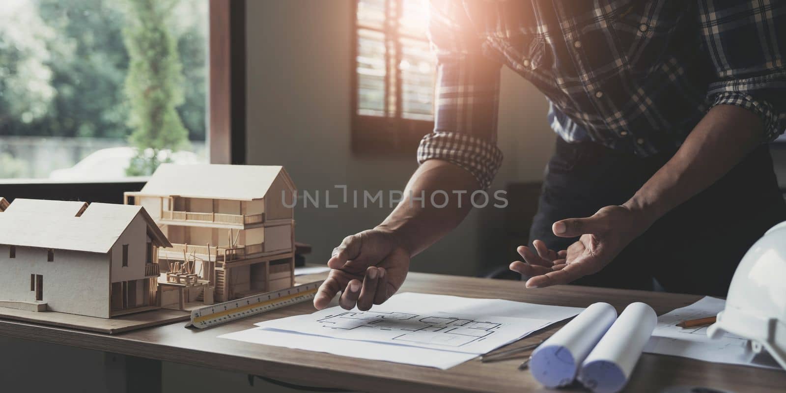 Concept architects, engineer holding pen pointing equipment architects On the desk with a blueprint in the office, Vintage, Sunset light.Selective Focus by wichayada