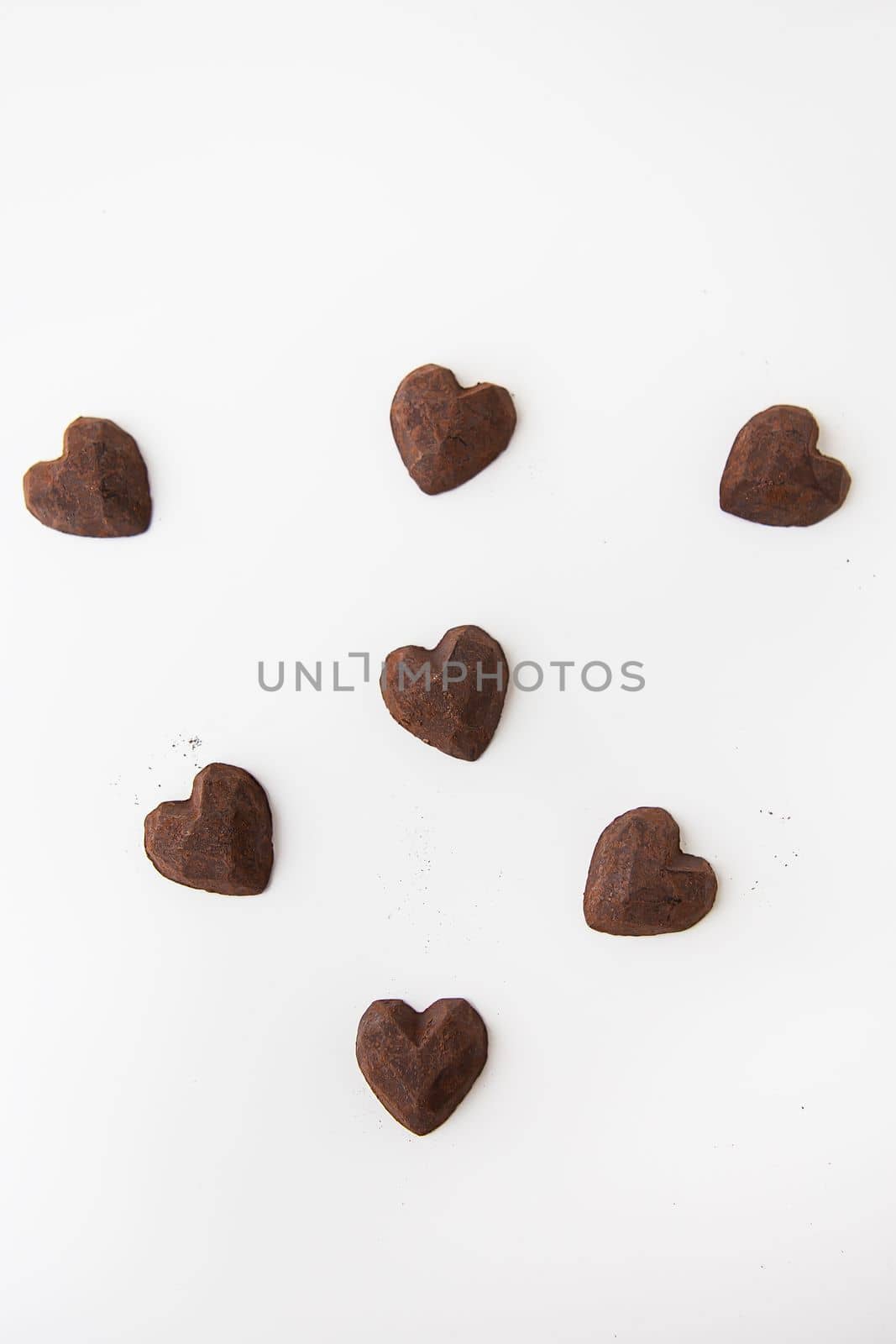 Truffle chocolate candies in the form of a heart on a white background. by sfinks