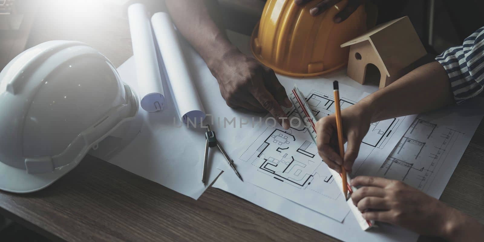 Builder two asian young engineer man and architect woman are discussing construction from a plan to follow the project to build an industrial plant at site. Worker concept. by wichayada