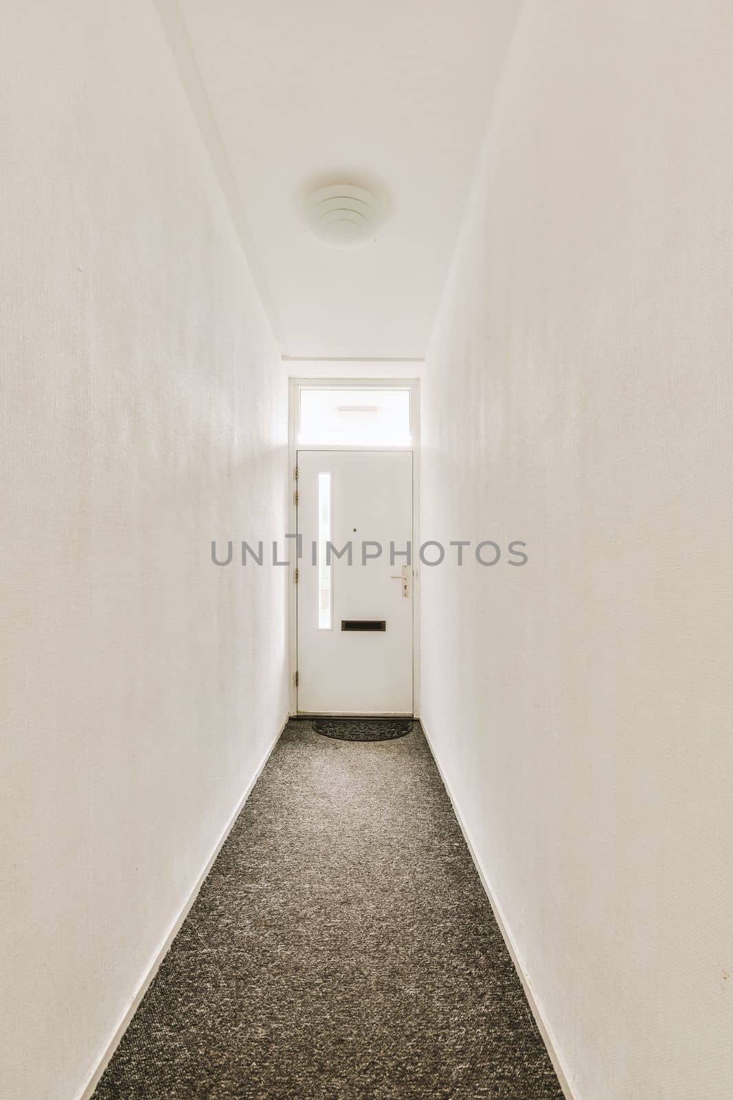 Interior of modern flat in minimal style with narrow empty corridor illuminated by lamps