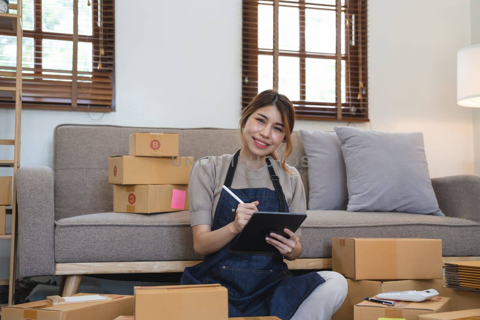 Asian woman freelancer sme business online shopping working with parcel box at home - SME business online and delivery concept.