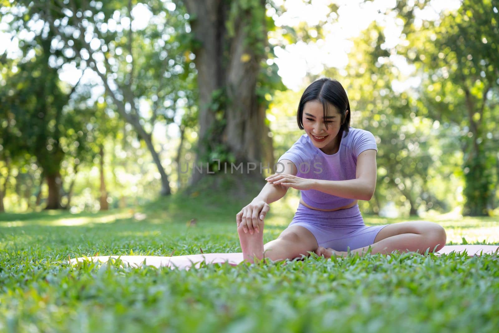 Portrait of a young woman doing yoga in the garden for a workout. Concept of lifestyle fitness and healthy. Asian women are practicing yoga in the park. by nateemee