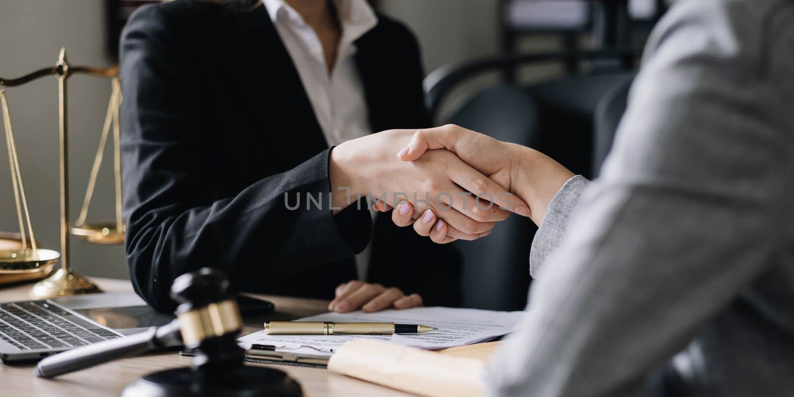 Closeup businesswoman Shaking hands with lawyer after discussing good deal in office by wichayada