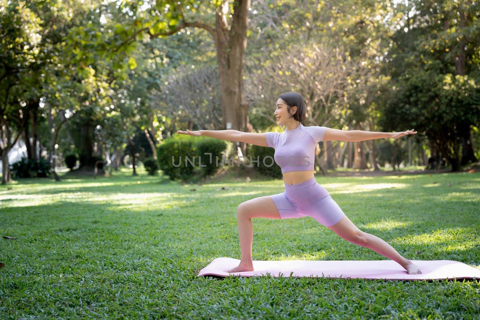 Portrait of a young woman doing yoga in the garden for a workout. Concept of lifestyle fitness and healthy. Asian women are practicing yoga in the park