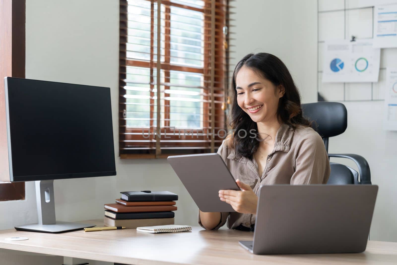 Asian woman accountant preparing annual financial report checking result on calculator bookkeeping. female freelancer counting tax rates declaring income