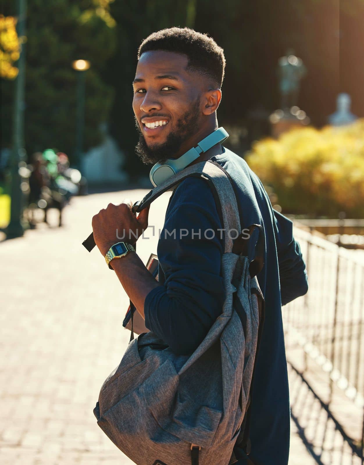 Black man, student on campus for university in outdoor portrait, education and study with backpack. College, smile and higher education with learning for development and scholarship, going to class. by YuriArcurs