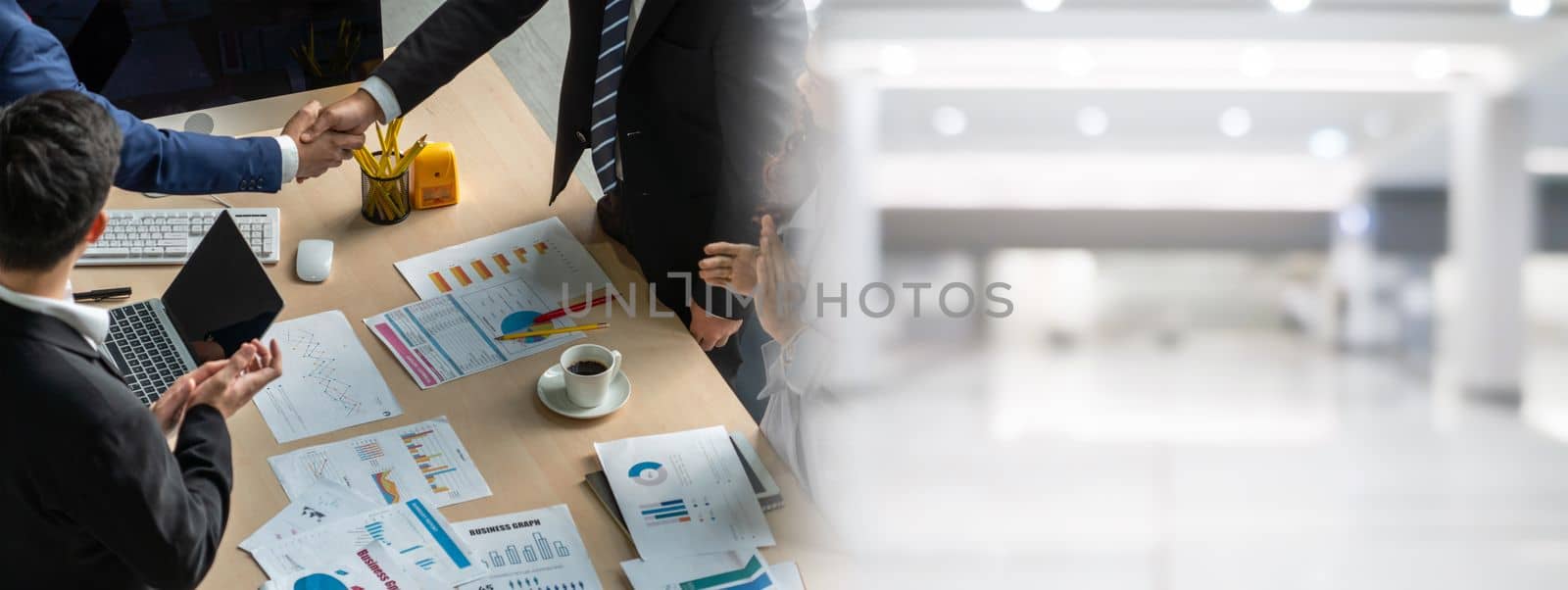 Group business people handshake at meeting table in widen view in office together with confident shot from top view . Young businessman and businesswoman workers express agreement of investment deal.