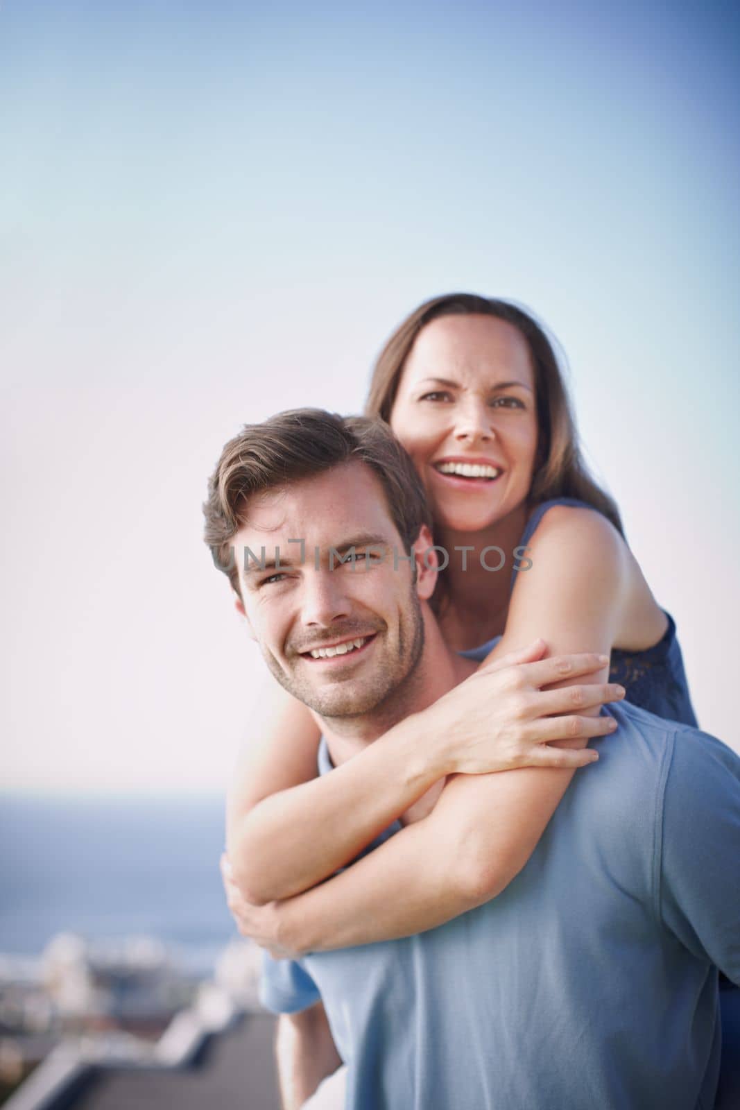 Moments of togetherness. A handsome man piggybacking his loving wife outdoors