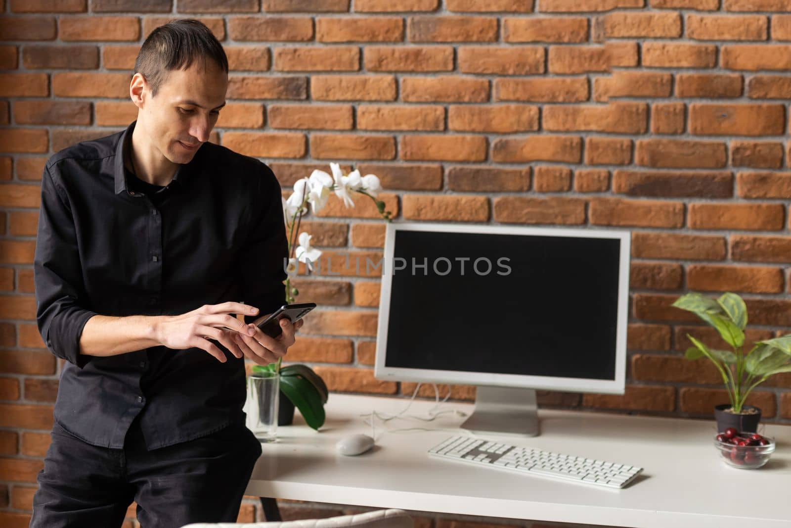 Mock Up Template. Happy Smiling Man Sitting On Desk Posing At Home Office, Free Copy Space. People, Technology, Remote Work Concept.