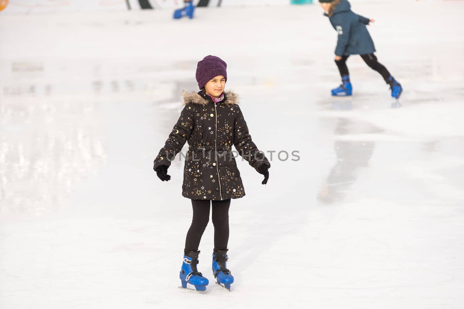 teenage girl ice skating on rink outdoors.