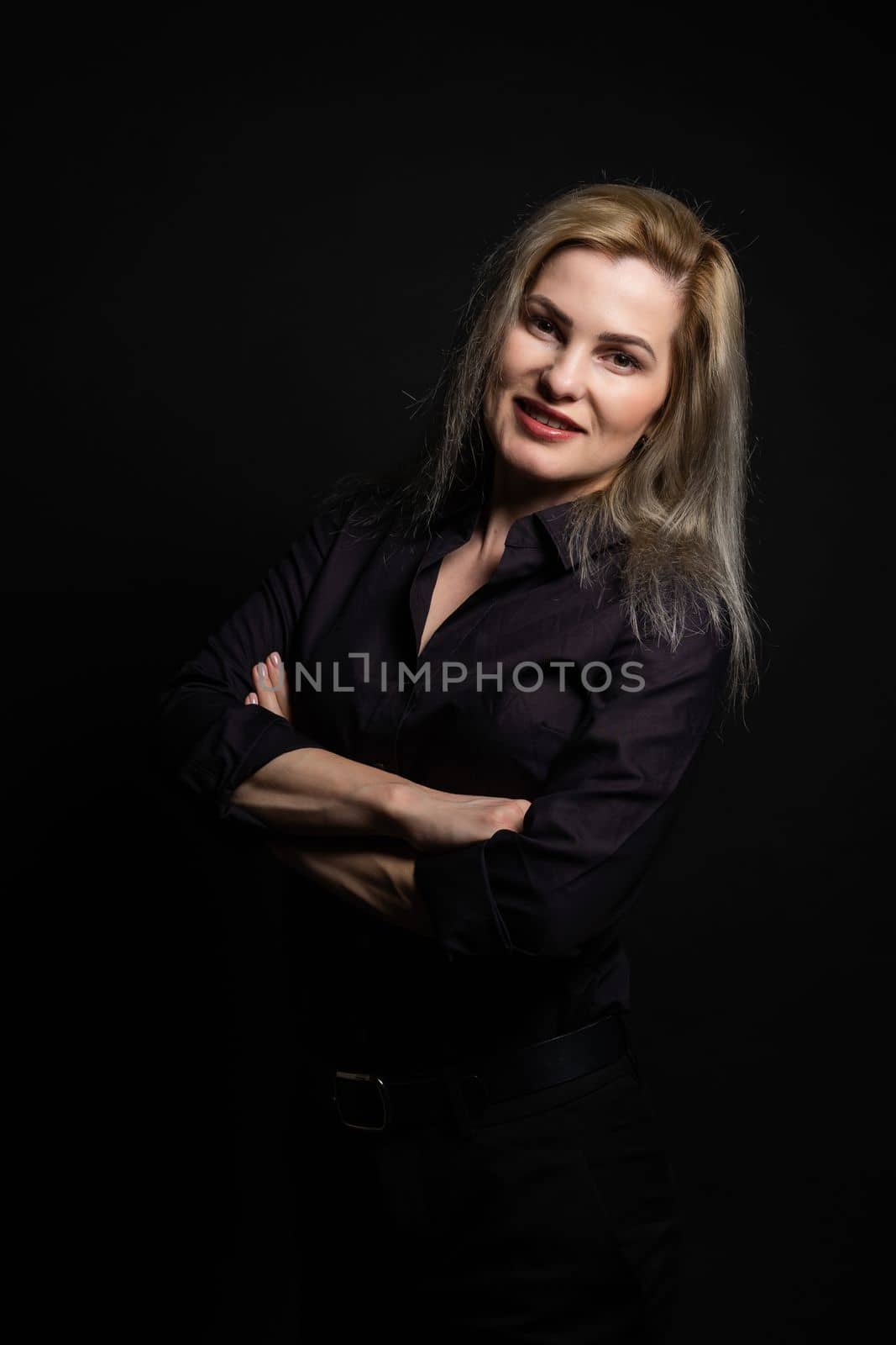 Beautiful middle-aged woman on a gray background in a black blouse. by Andelov13