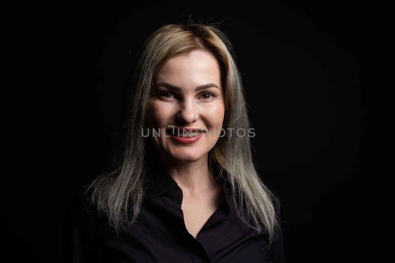 Blonde woman portrait, attractive adult girl in studio over black background.