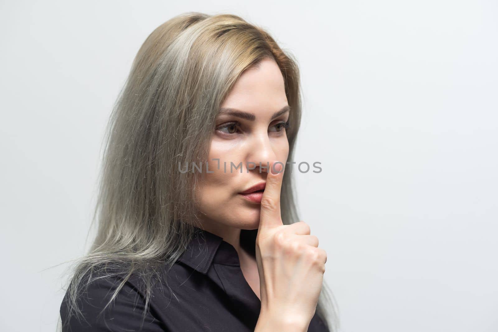beautiful blond woman shows sign of quiet, secret, isolated over gray background. by Andelov13