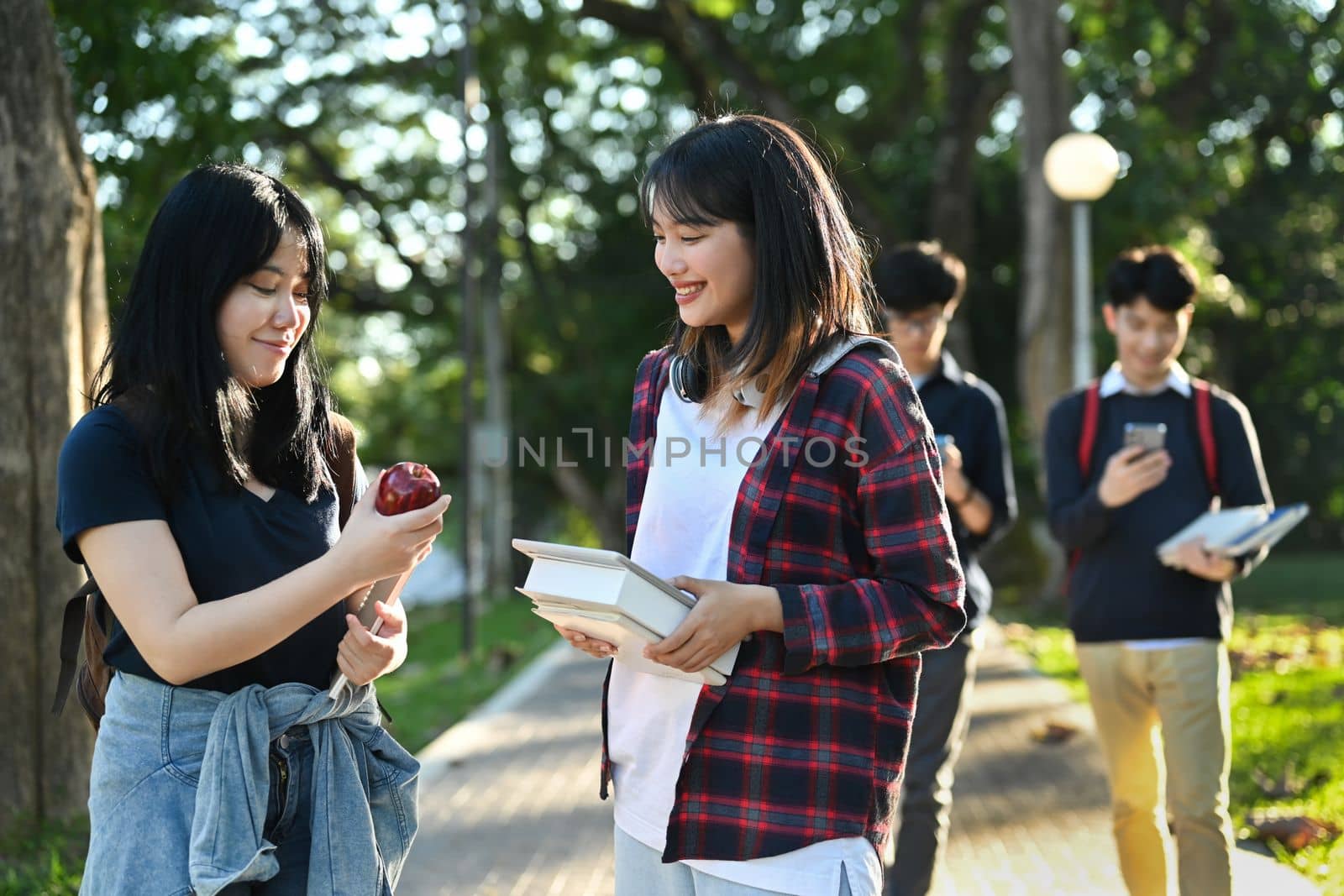 Happy university students going to college class, talking while walking in university campus. Youth lifestyle and friendship concept. 