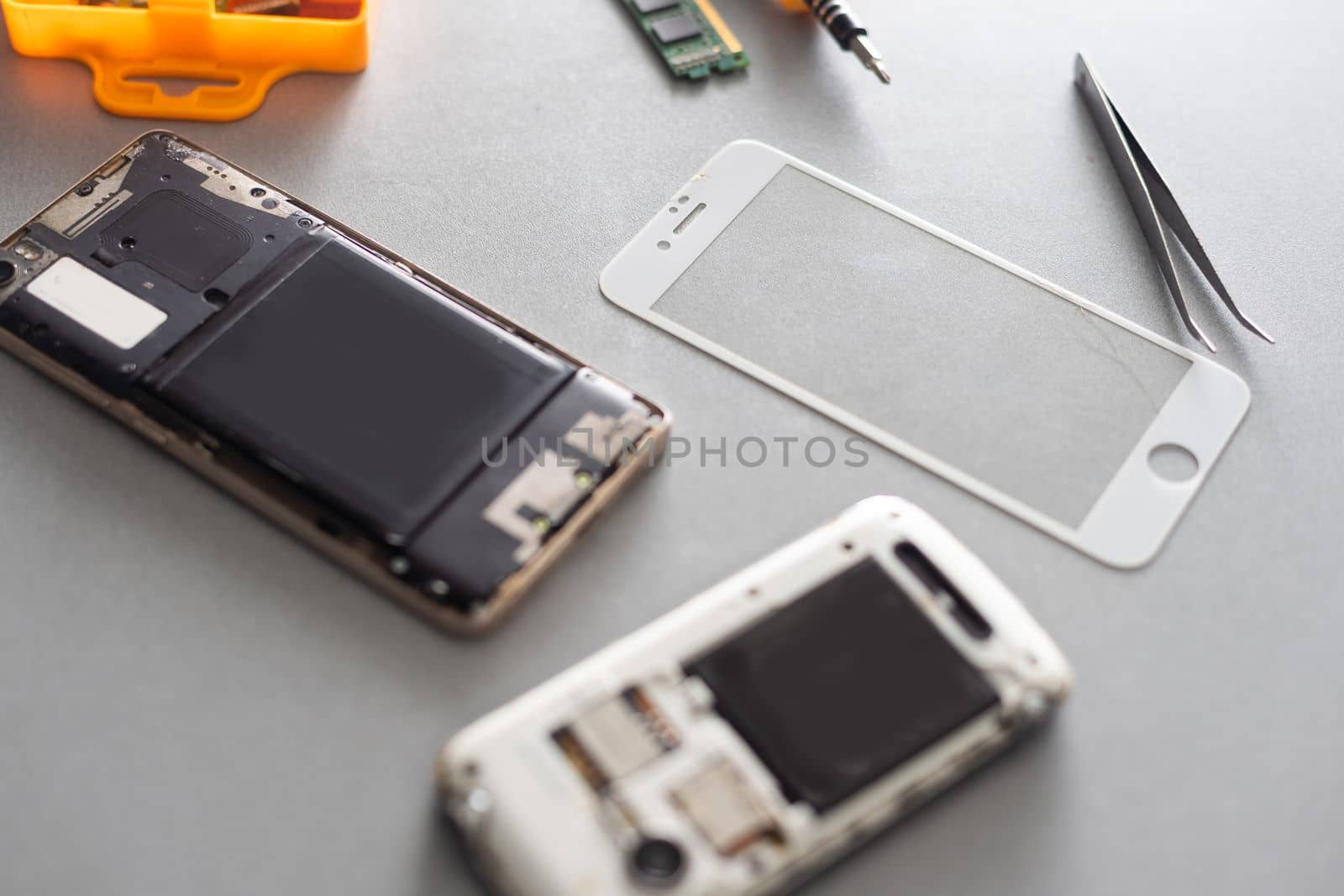 Technician repairing inside of mobile phone by soldering iron. the concept of data, hardware, technology