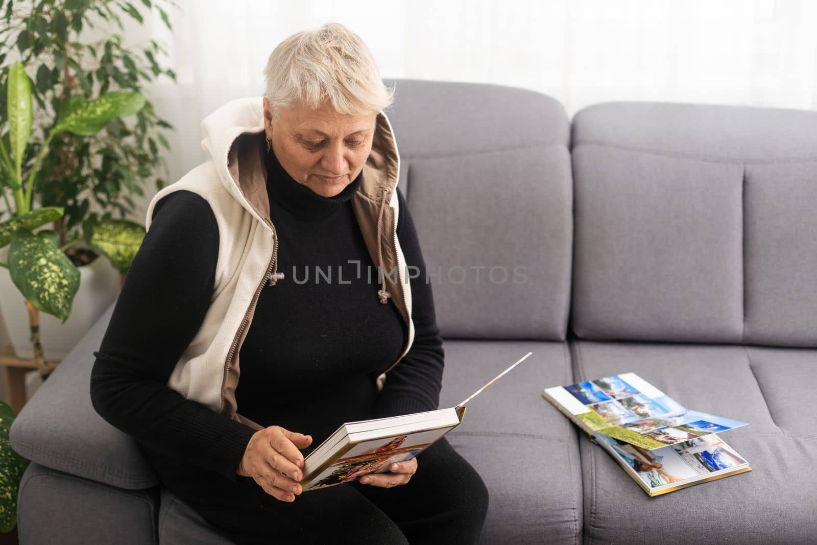 senior woman holding a family photo album, photo book.