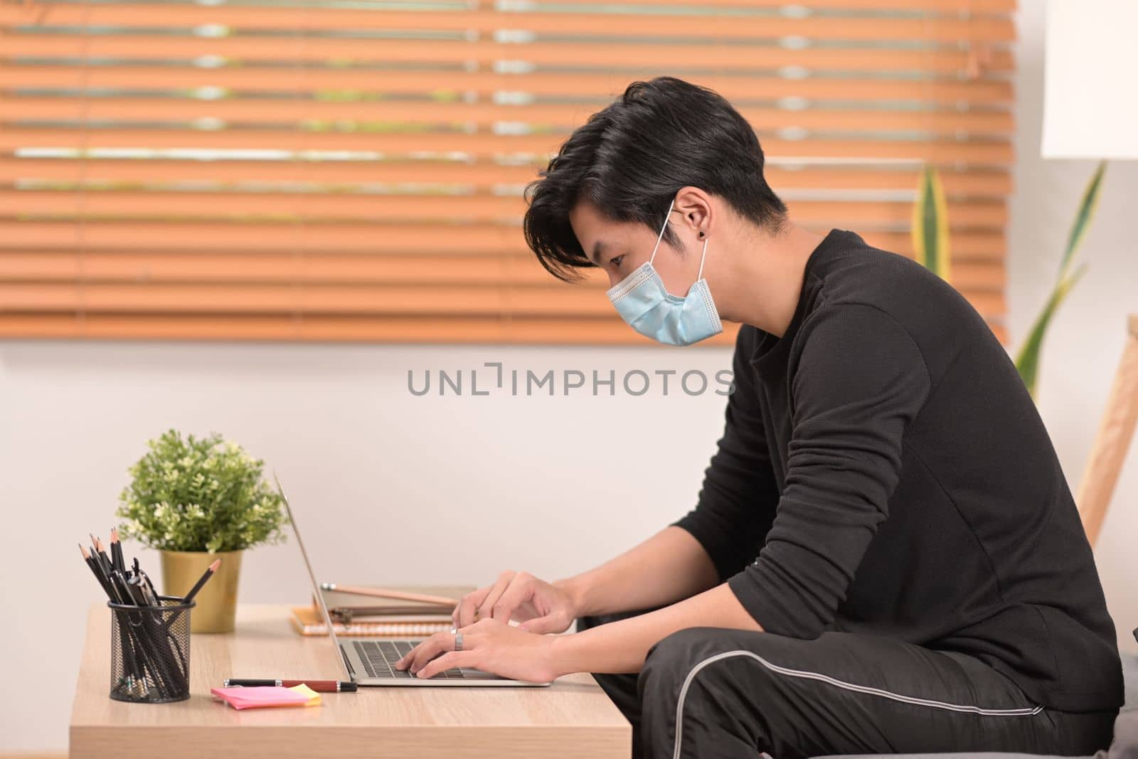 Asian man using computer tablet in living room.