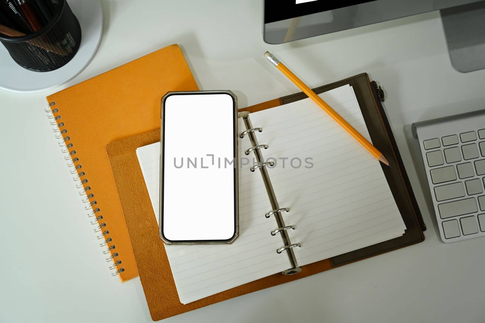 Mock up smart phone, notebook and coffee cup on white table. by prathanchorruangsak