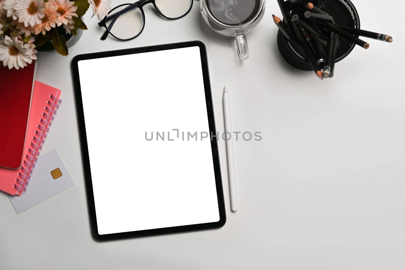 Top view digital tablet, stylus pen, glasses and notebook on white background. by prathanchorruangsak