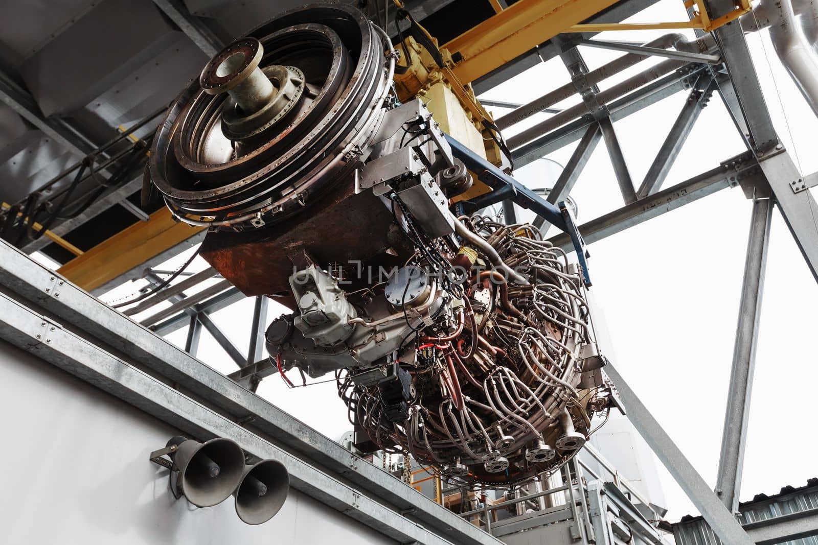 The engine of a gas turbine compressor hangs on a crane during installation in a module for generating electricity