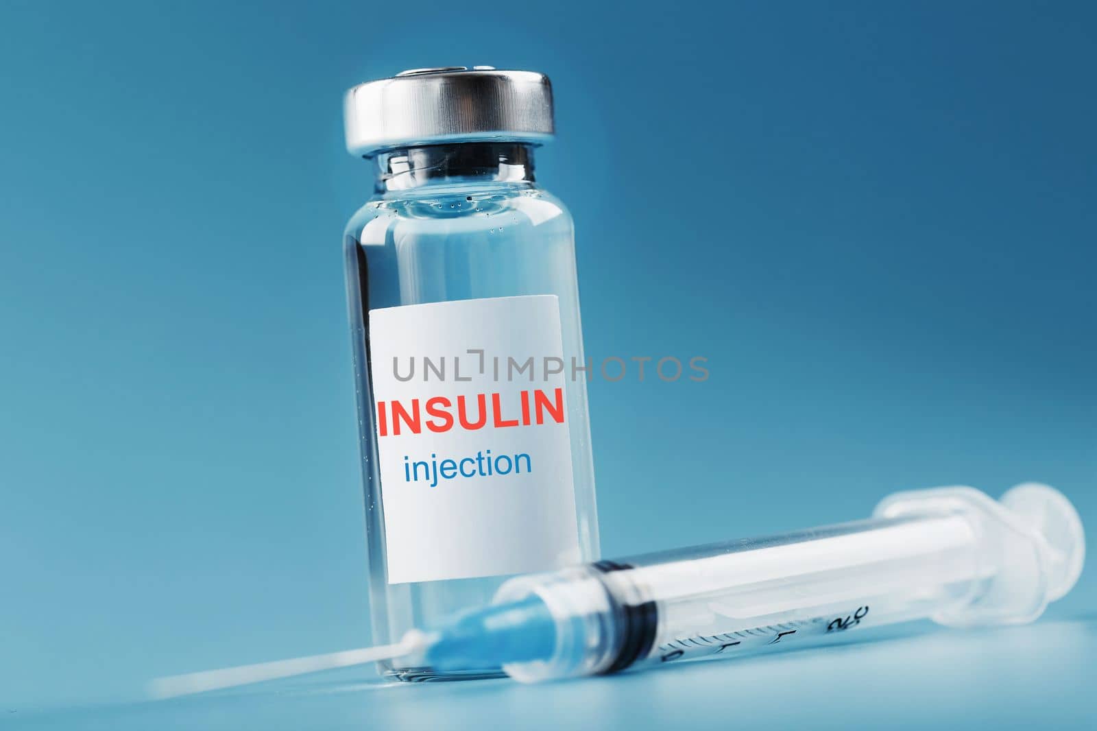 A bottle of insulin hormone and a syringe on the table by AlexGrec