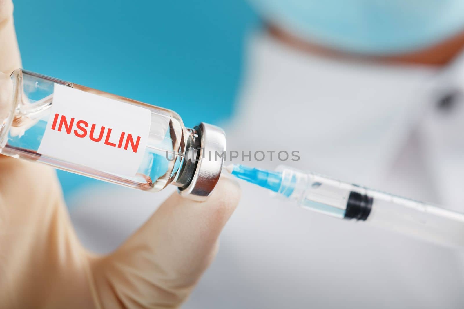 Diabetes treatment a bottle of insulin and a syringe with a needle in the hands of a doctor by AlexGrec