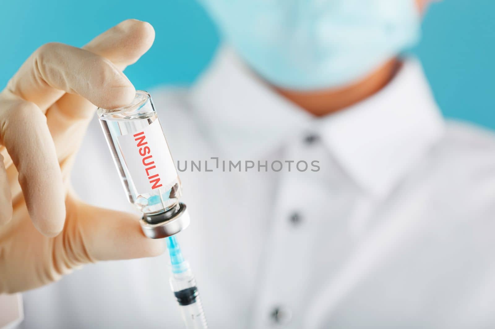 Diabetes treatment a bottle of insulin and a syringe with a needle in the hands of a doctor by AlexGrec