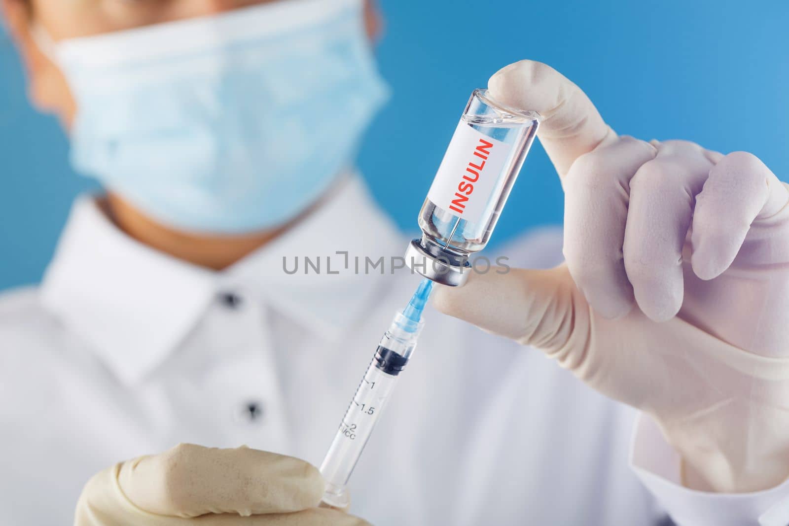 Diabetes treatment a bottle of insulin and a syringe with a needle in the hands of a doctor by AlexGrec