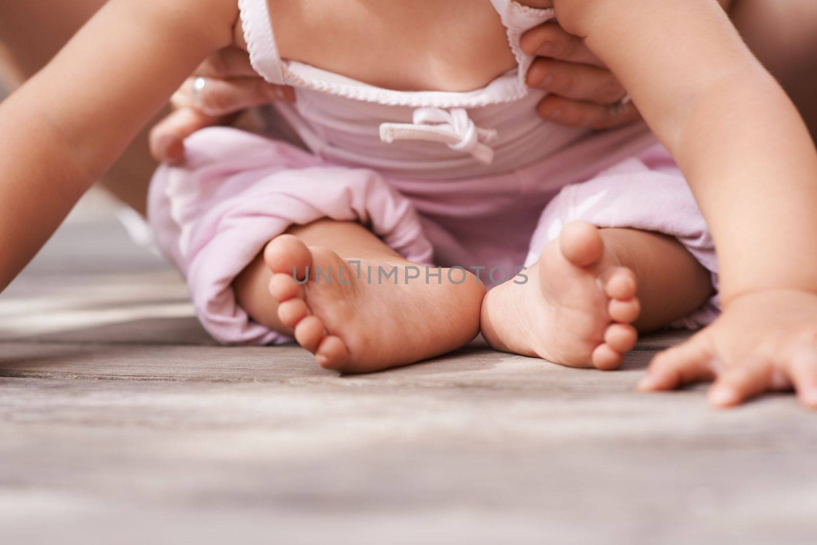 Precious moments. Closeup image of a babys feet as she sits outside with her mother