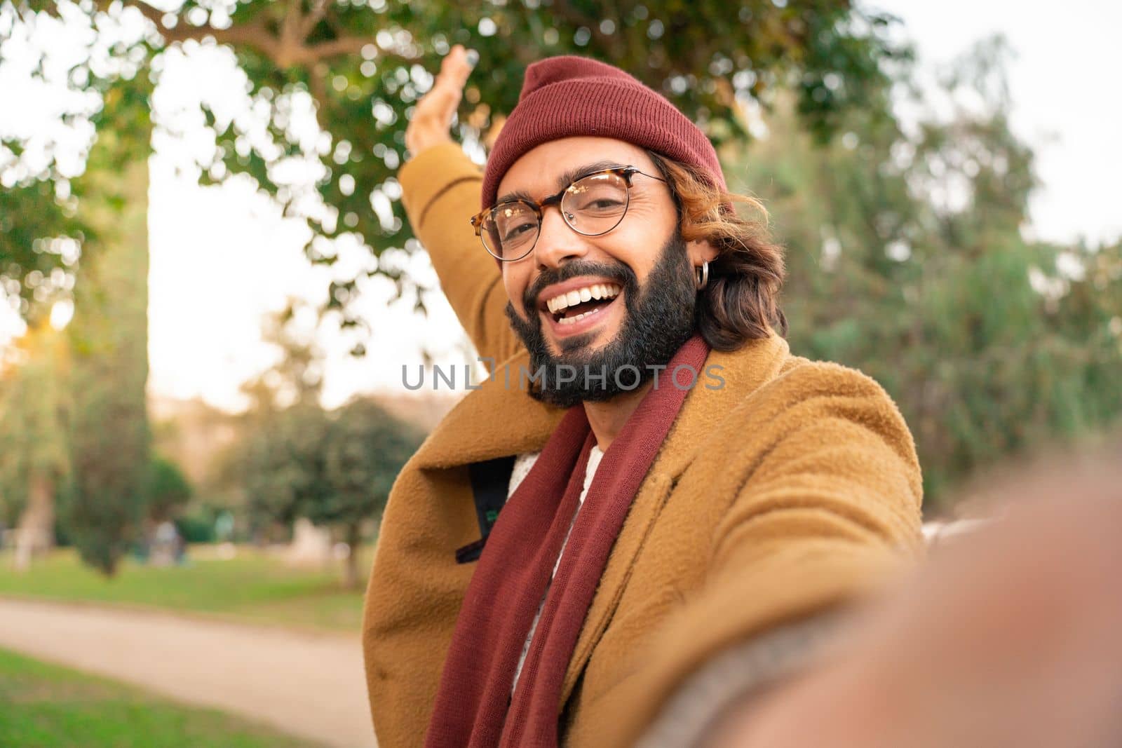 Happy young caucasian man with glasses and beard taking a selfie outdoors in the park in winter. by PaulCarr