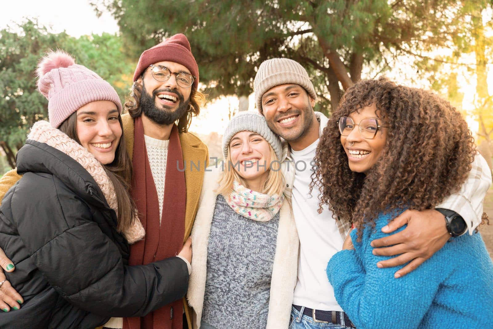 Happy friends from diverse cultures and races taking selfie looking at camera smiling outdoors. by PaulCarr