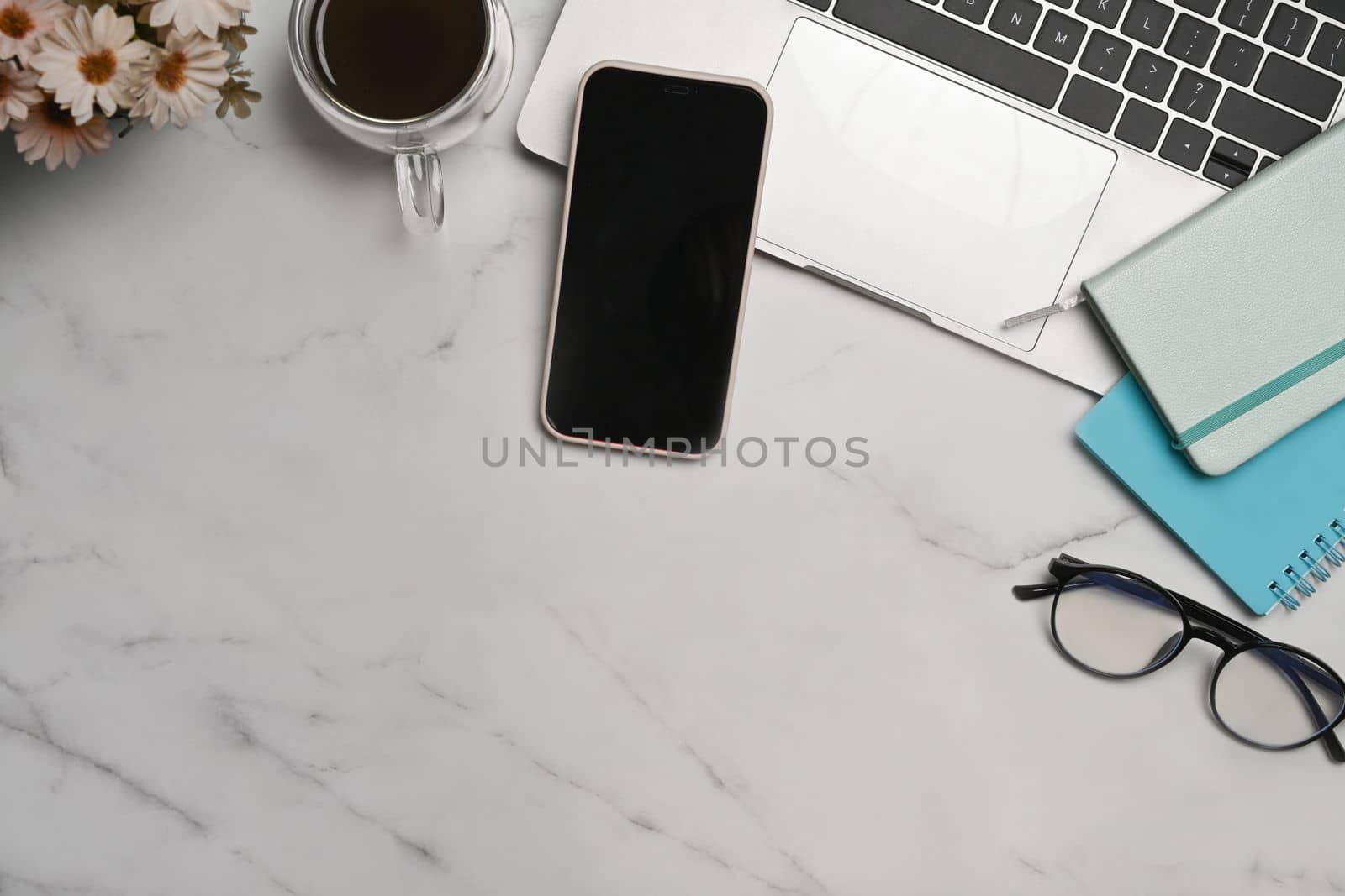 Smart phone, laptop computer and coffee cup on marble background.