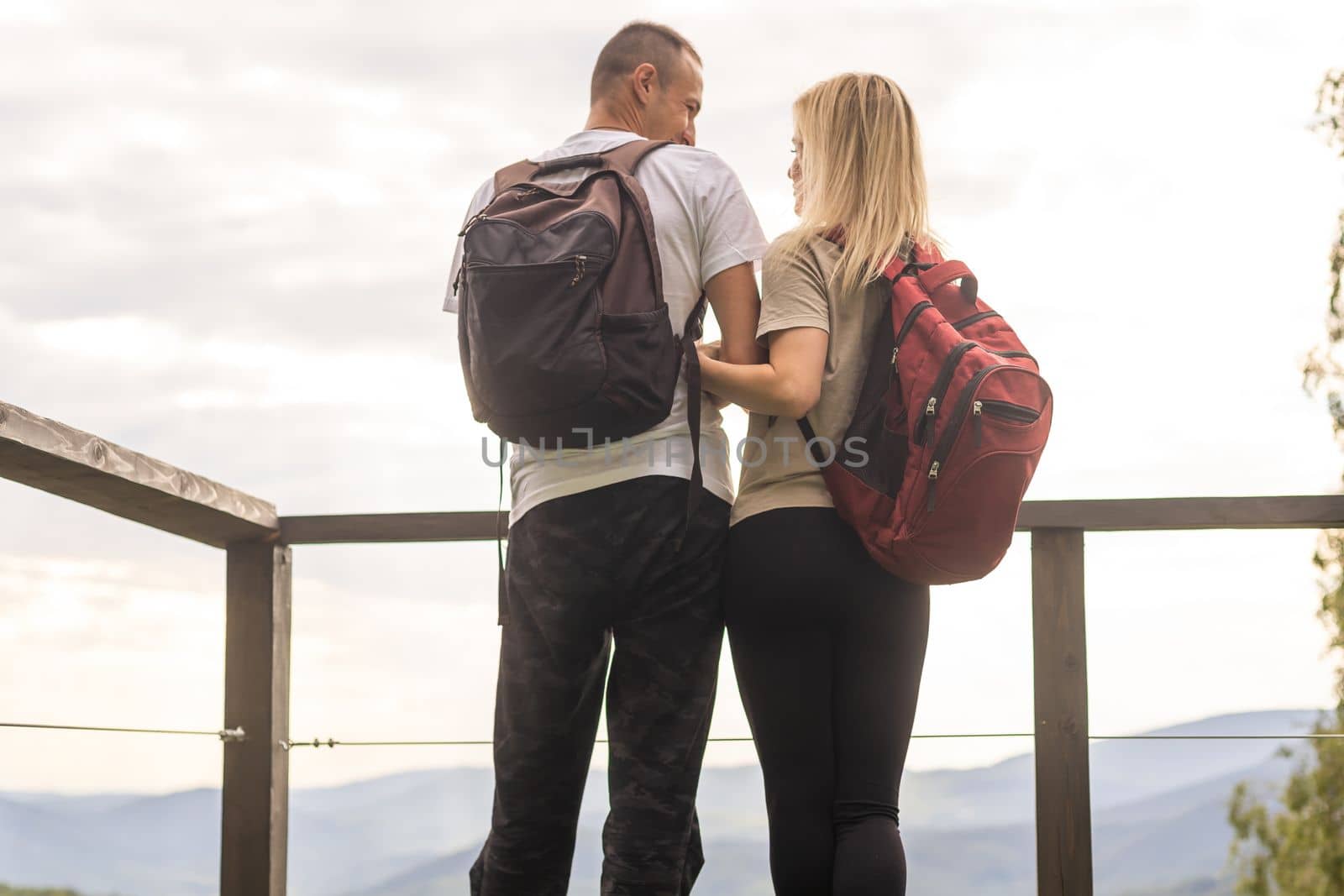 Two hikers relax on top of a mountain with great view