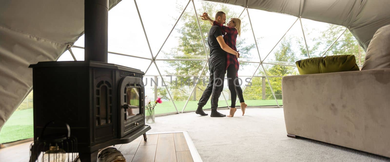 a couple in geo dome tents. Cozy, camping, glamping, holiday, vacation lifestyle concept. Outdoors cabin, scenic background