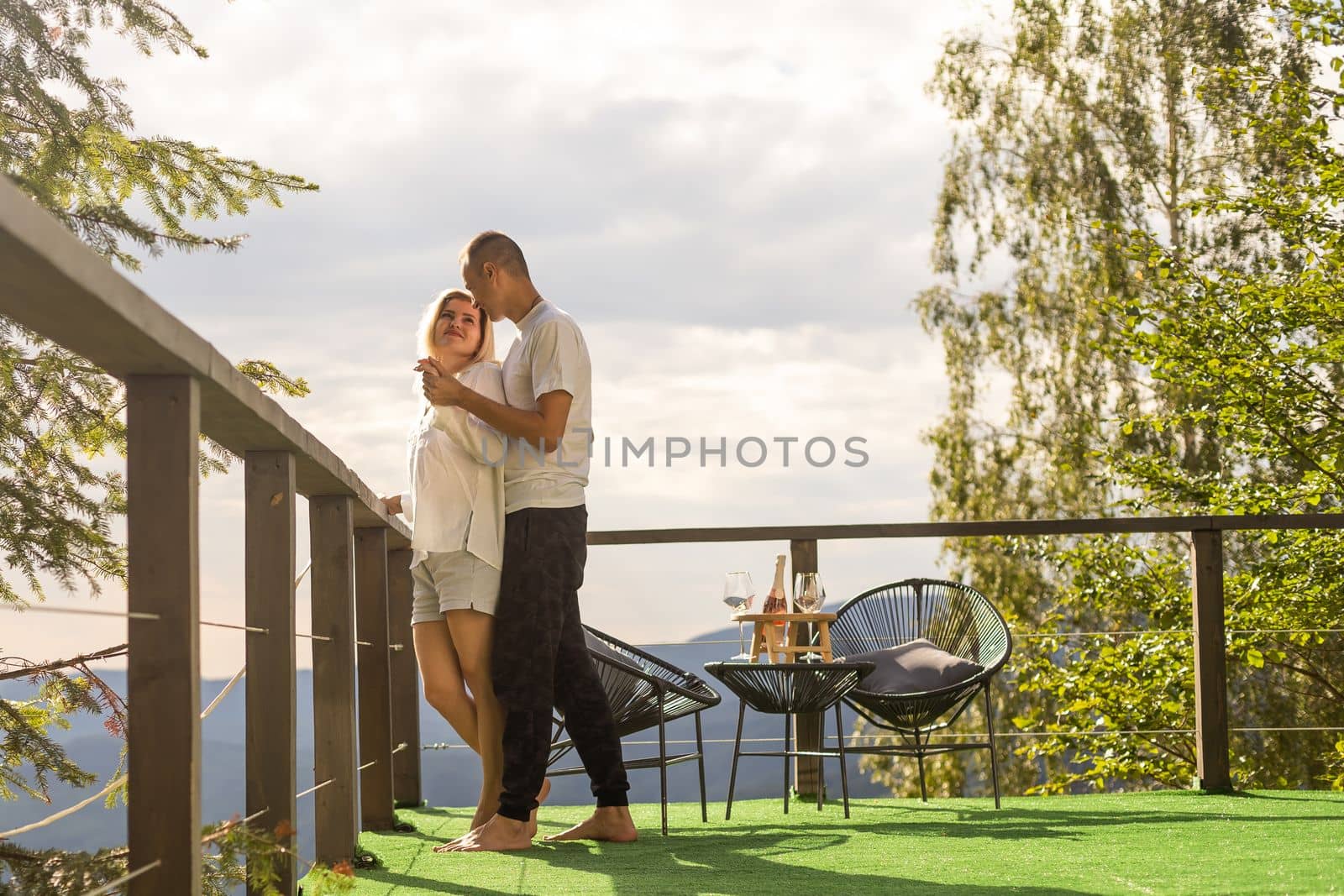 Couple on the balcony against the backdrop of mountains. life terrace pretty happiness summer home