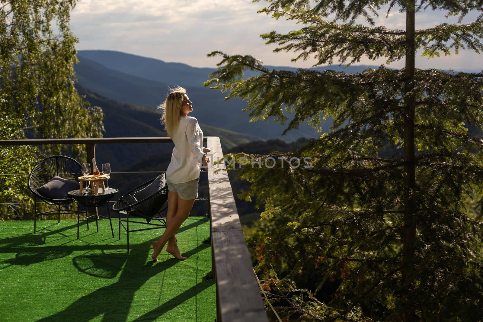 Young beautiful woman on the terrace in the mountains.