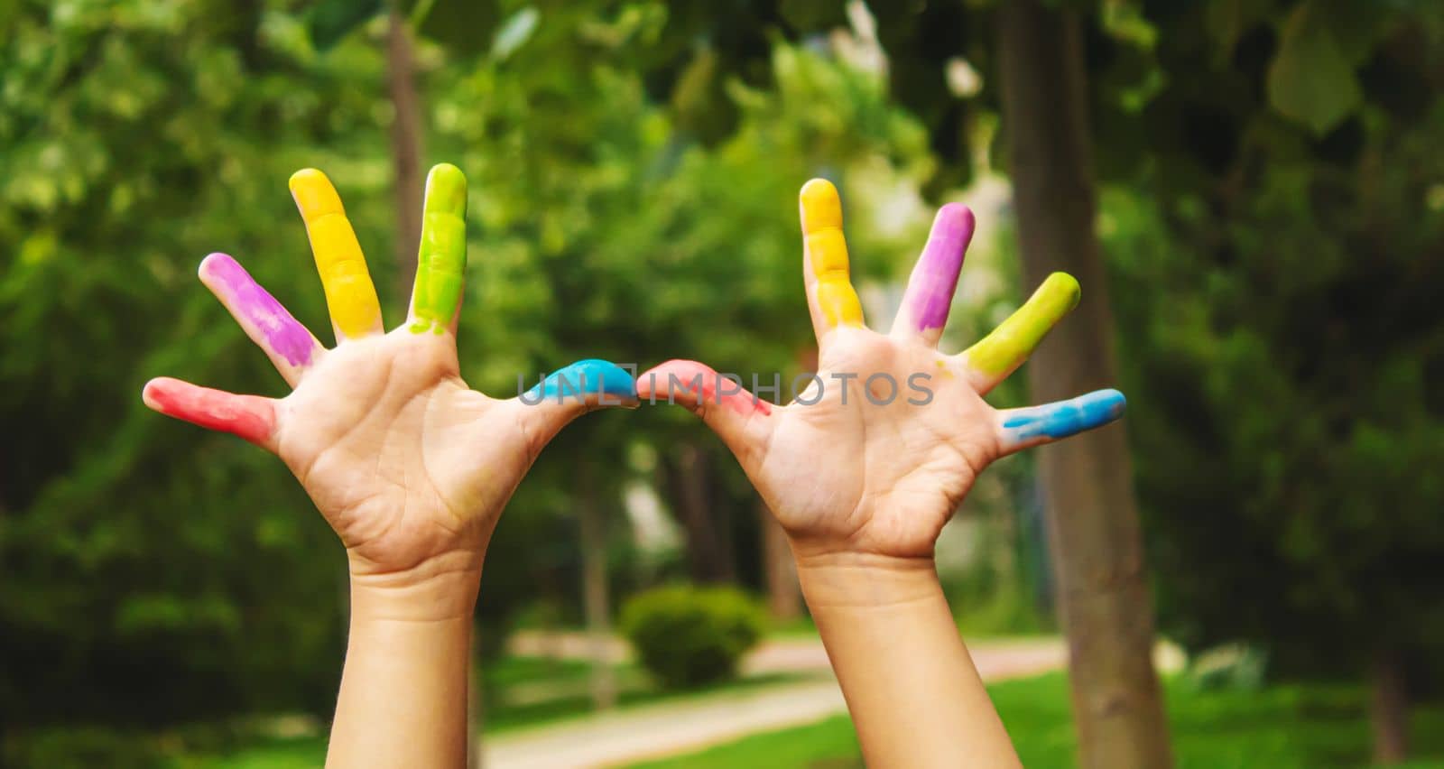 Children's hands in the colors of summer. Selective focus.arts