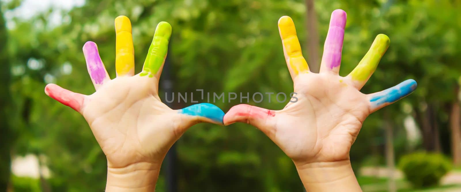 Children's hands in the colors of summer. Selective focus.arts