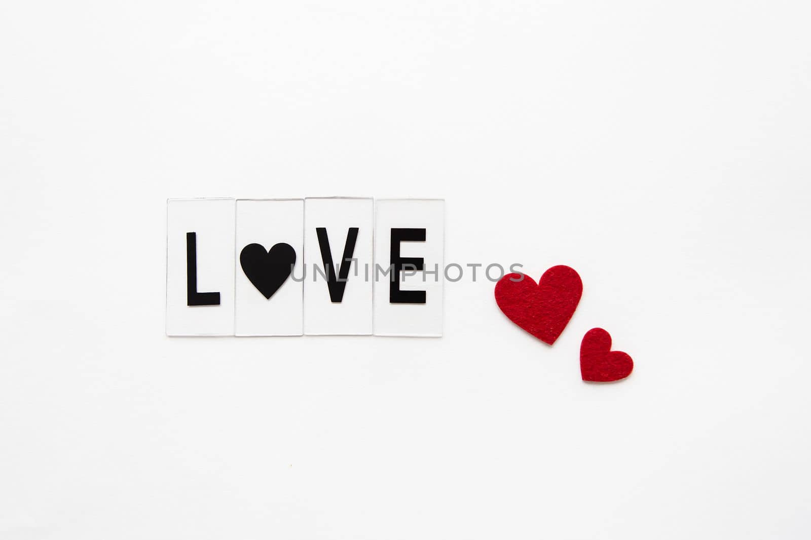 Beautiful inscription love on a white background, small red hearts. Postcard