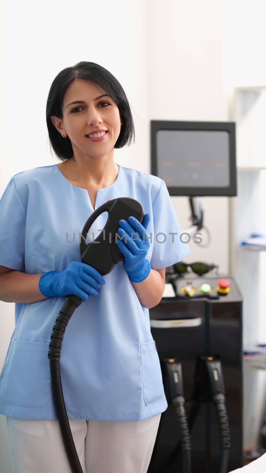 Portrait of laser hair removal master. Woman cosmetologist doctor holding device for laser hair removal in hands and looking at camera