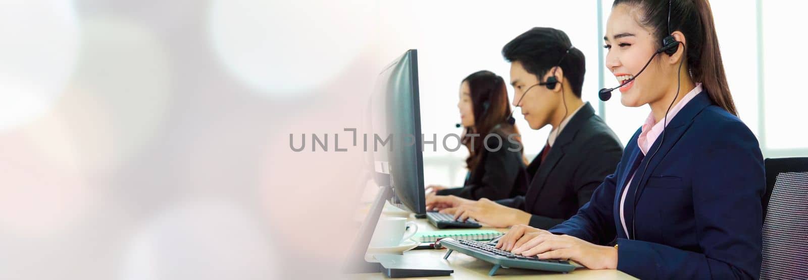 Business people wearing headset working in office in widen view to support remote customer or colleague. Call center, telemarketing, customer support agent provide service on telephone video call.